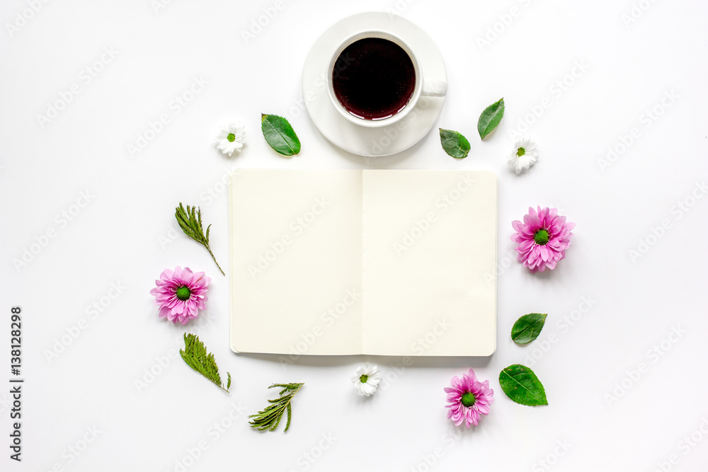 Petals, cup and copybook on table background top view mock up