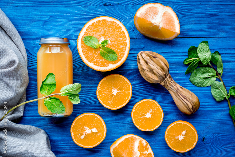 Orange juice in bottle with slices and mint on table top view