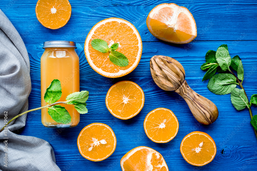 Orange juice in bottle with slices and mint on table top view