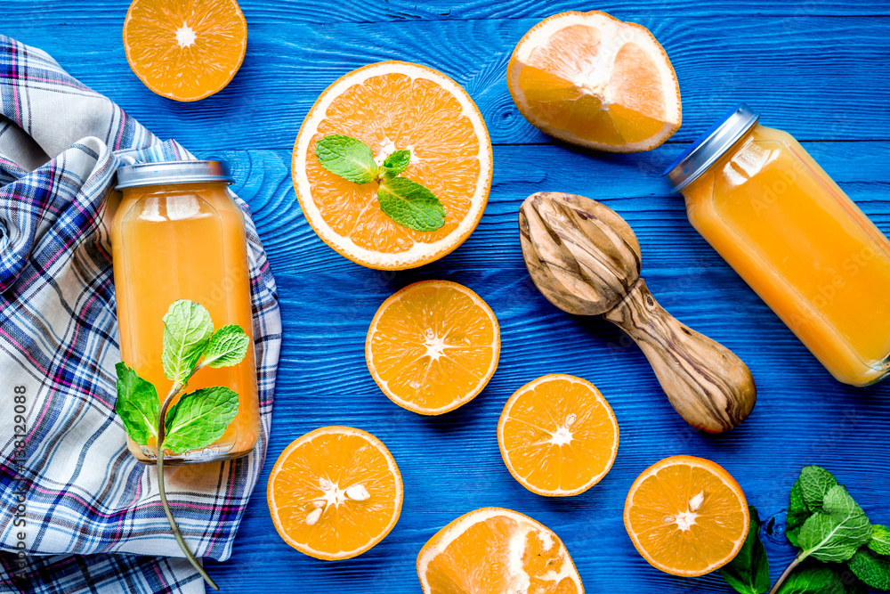 Homemade juice bottles with orange and mint on table top view