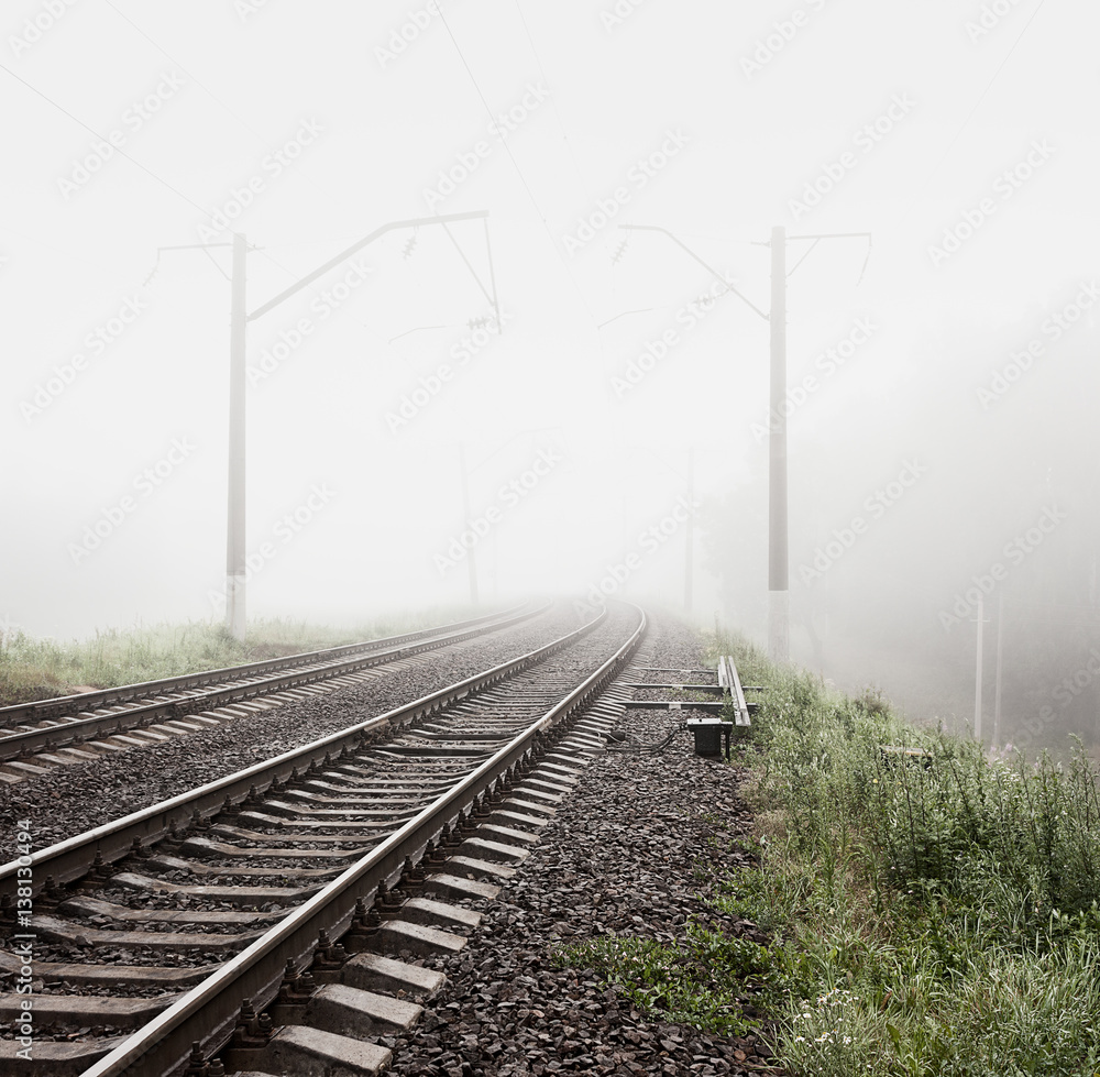 Railway in Fog. Misty Morning Landscape. Empty Railroad. Toned and Filtered Photo with Copy Space. M