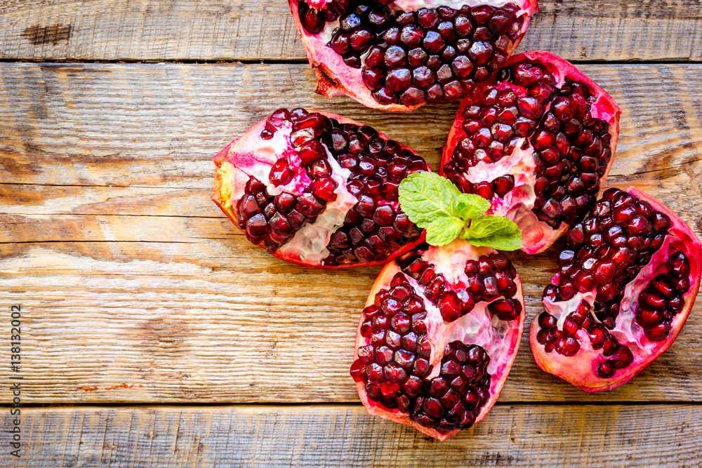 sliced pomegranate on wooden background top view