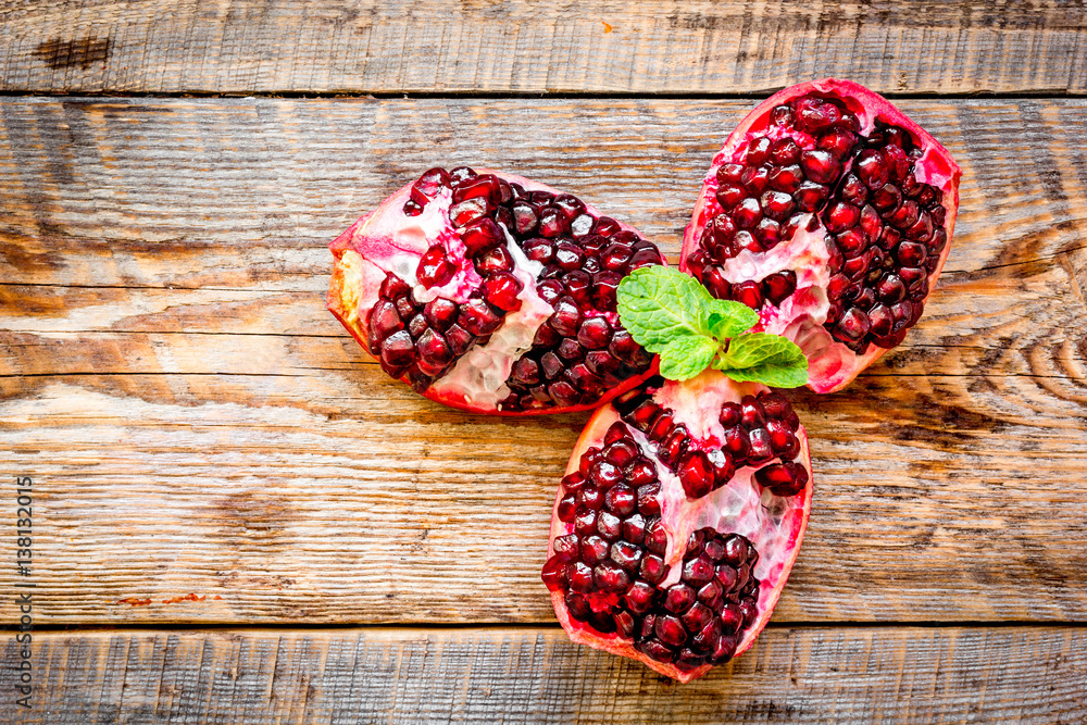 sliced pomegranate on wooden background top view