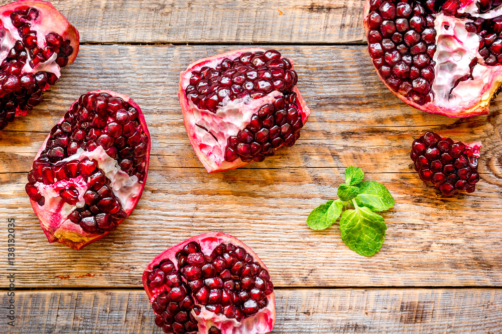 sliced pomegranate on wooden background top view