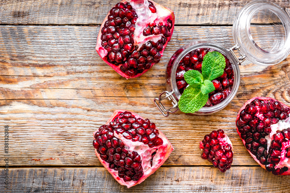 sliced pomegranate on wooden background top view