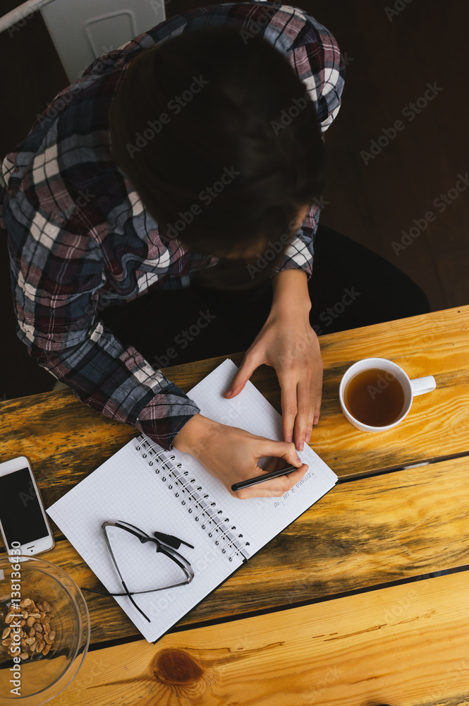 Topview of student girl writing notes at home