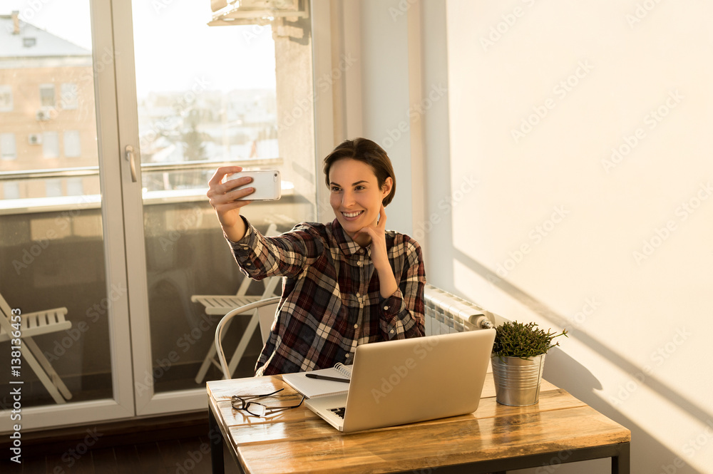 Girl taking selfie from home office while having a break from project