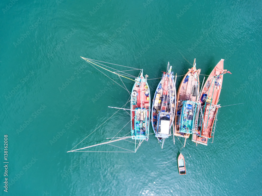 Fishing boat floating in the sea. The beautiful bright blue water in a clear day.