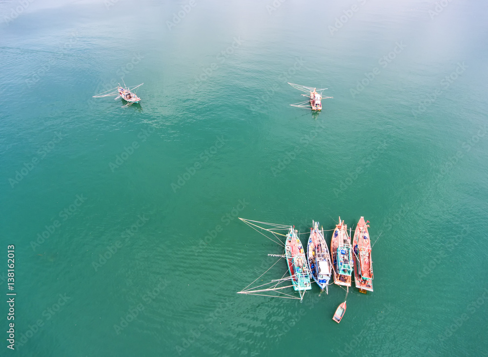 Fishing boat floating in the sea. The beautiful bright blue water in a clear day.