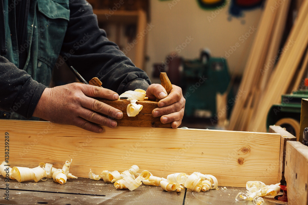 Hands of a carpenter planed wood