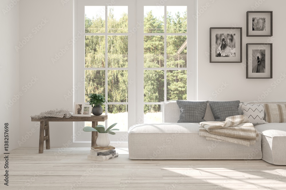 White room with sofa and green landscape in window. Scandinavian interior design