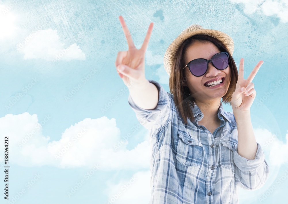 Woman with sunglasses smiling against sky with flare background