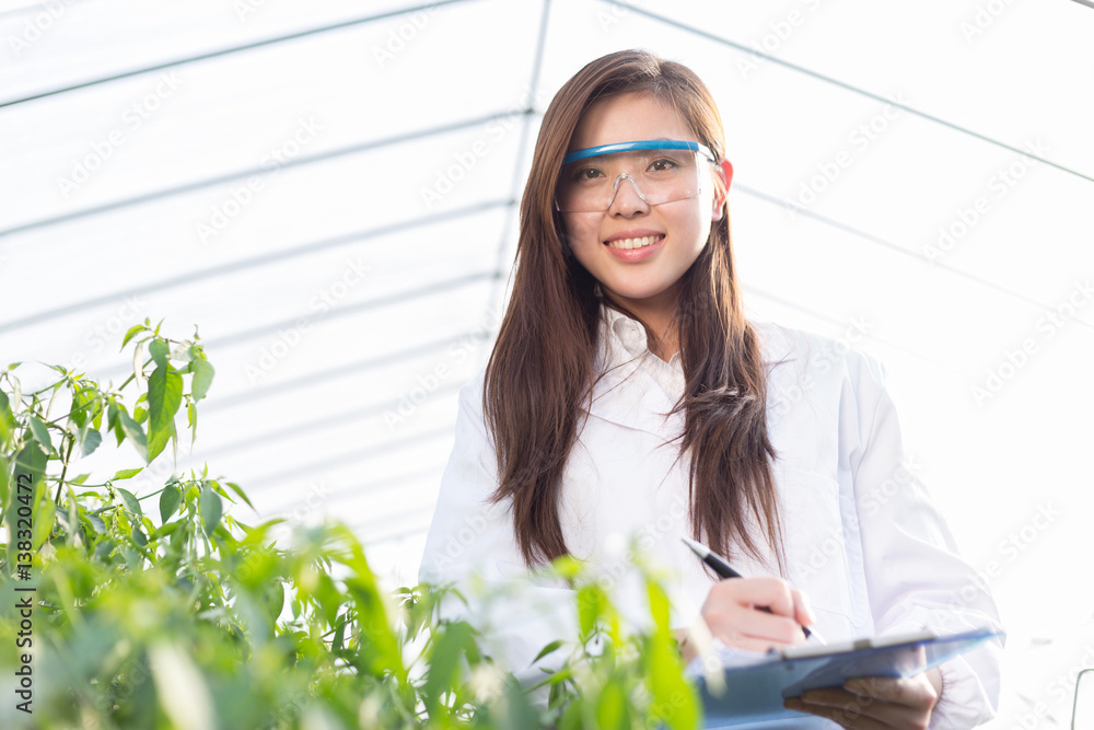 young asian woman working in green house