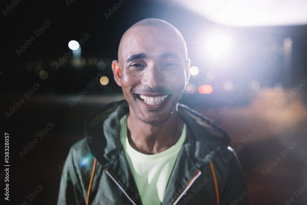 Smiling runner standing in city at night