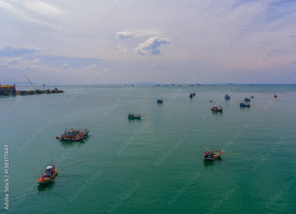 Fishing boat floating in the sea. The beautiful bright blue water in a clear day.Aerial view.Top vie