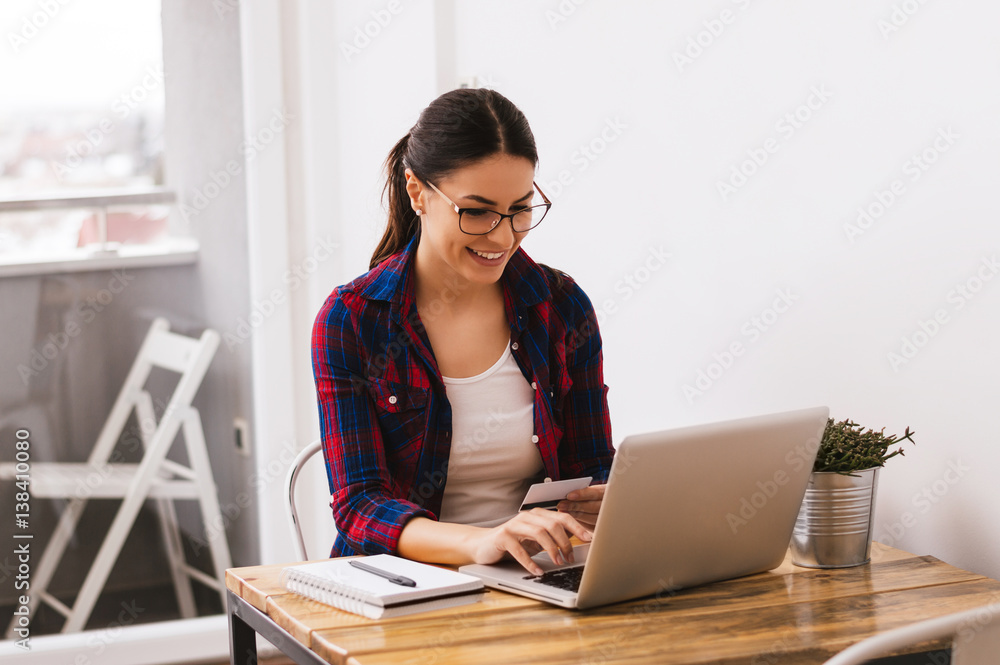 Successful entrepreneur woman smiling in satisfaction while shopping online from laptop computer whi