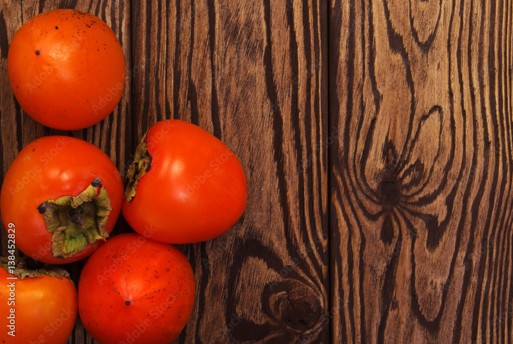  persimmon fruit on wooden background