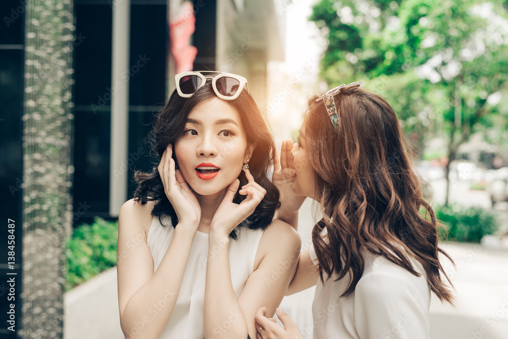 Happy young women talking outside the mall