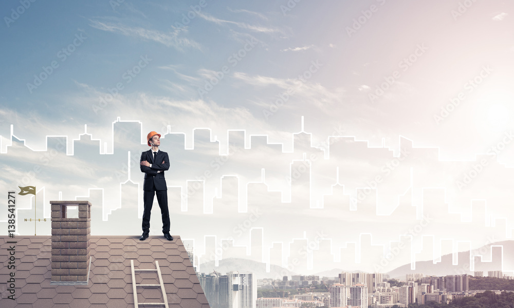 Engineer man standing on roof and looking away. Mixed media