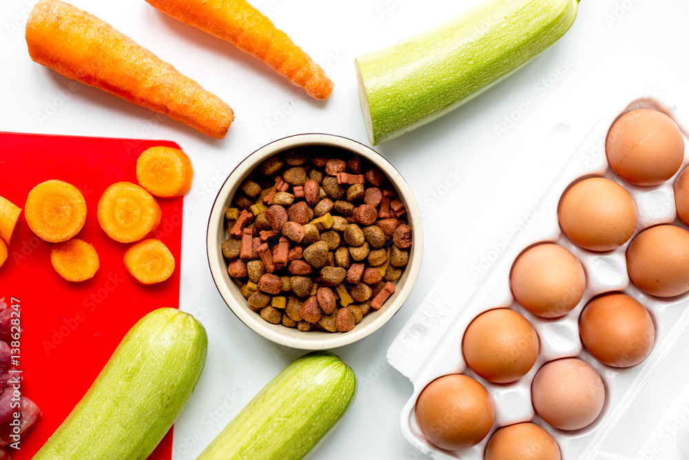 Dogfood set with vegetables, eggs and meat on table background top view