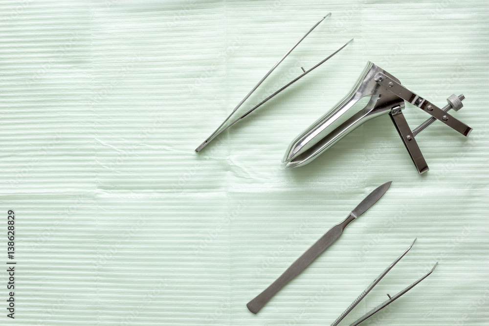 instruments of gynecologist on green background top view mock up