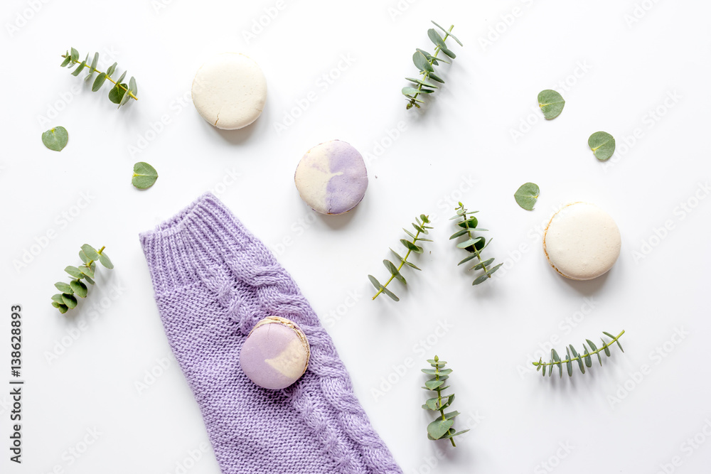 Macaroons and eucalyptus on woman table top view