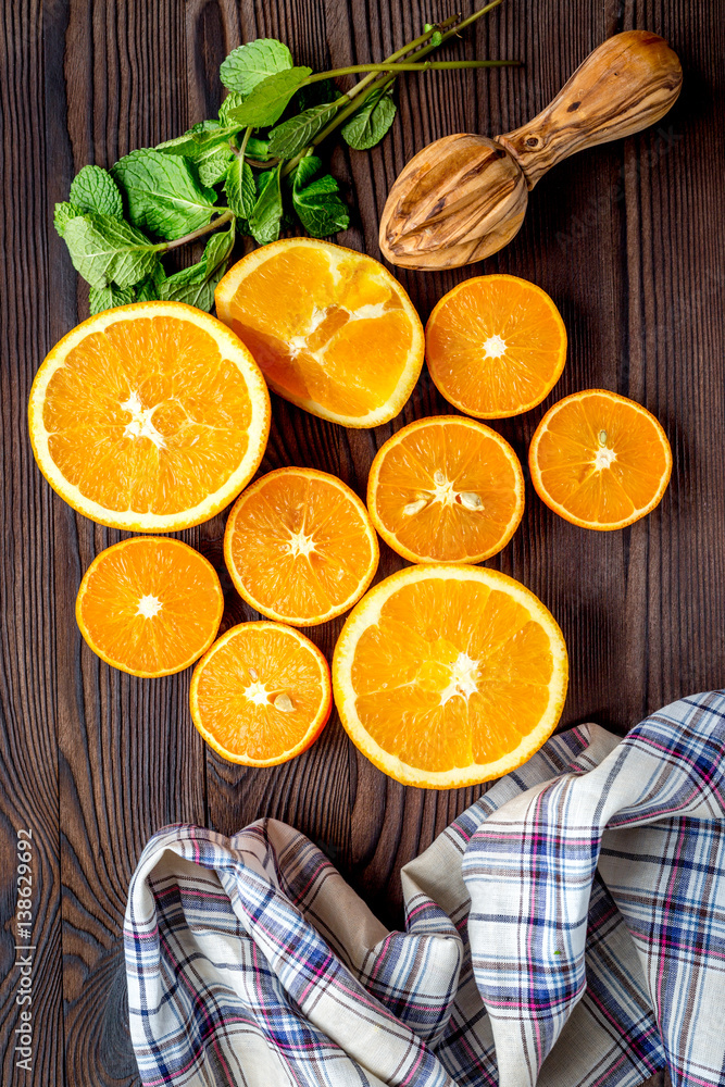 Fresh oranges in slices with mint leaves on kitchen top view