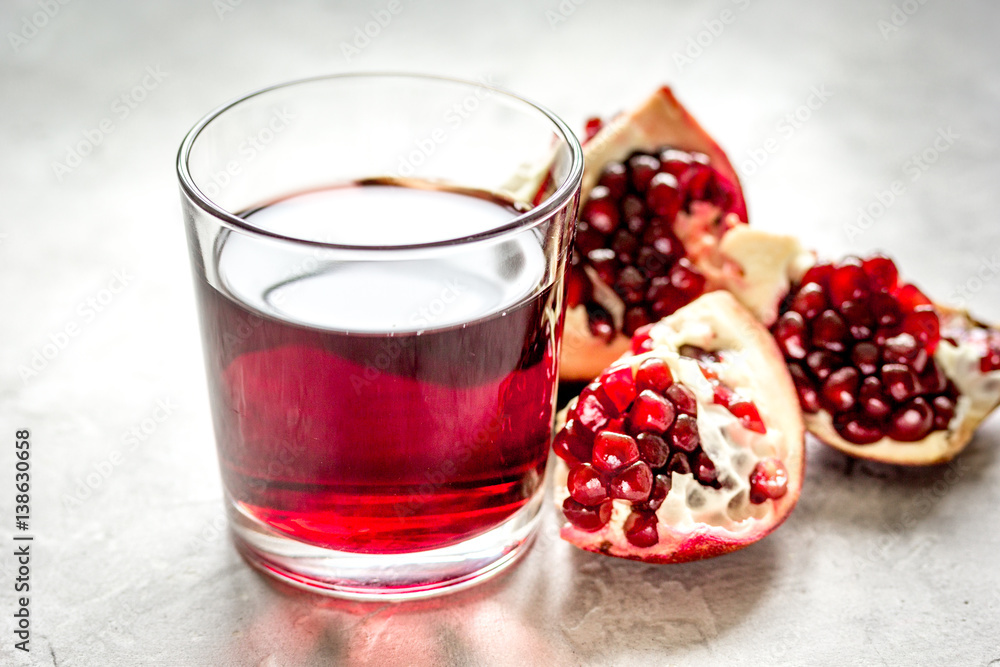 pomegranate juice with seed on stone table background