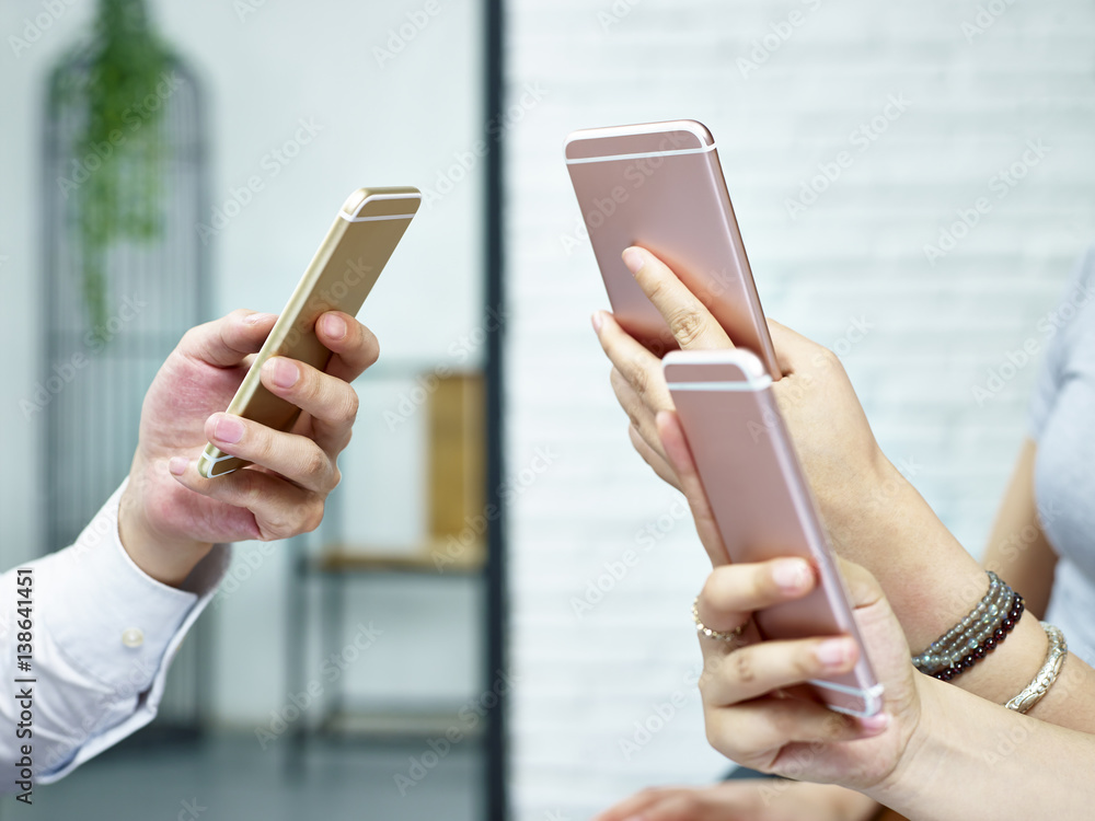 hands of young people playing with mobile phones