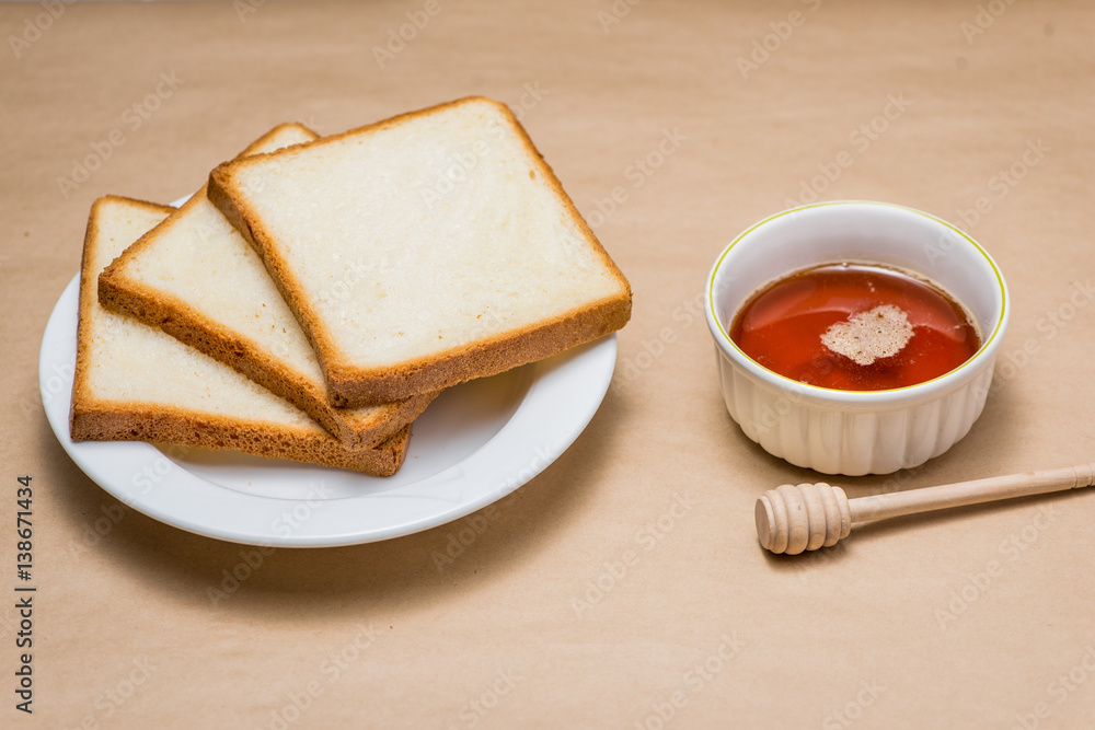 Close-up of slice of toast bread with honey on wood table