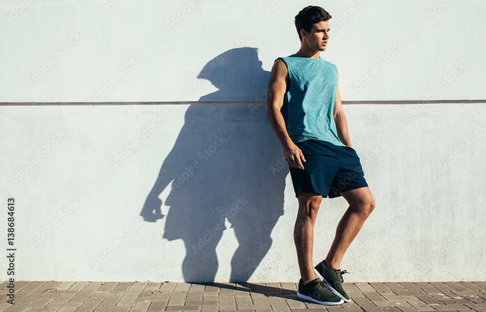 Fit young male relaxing after running exercise