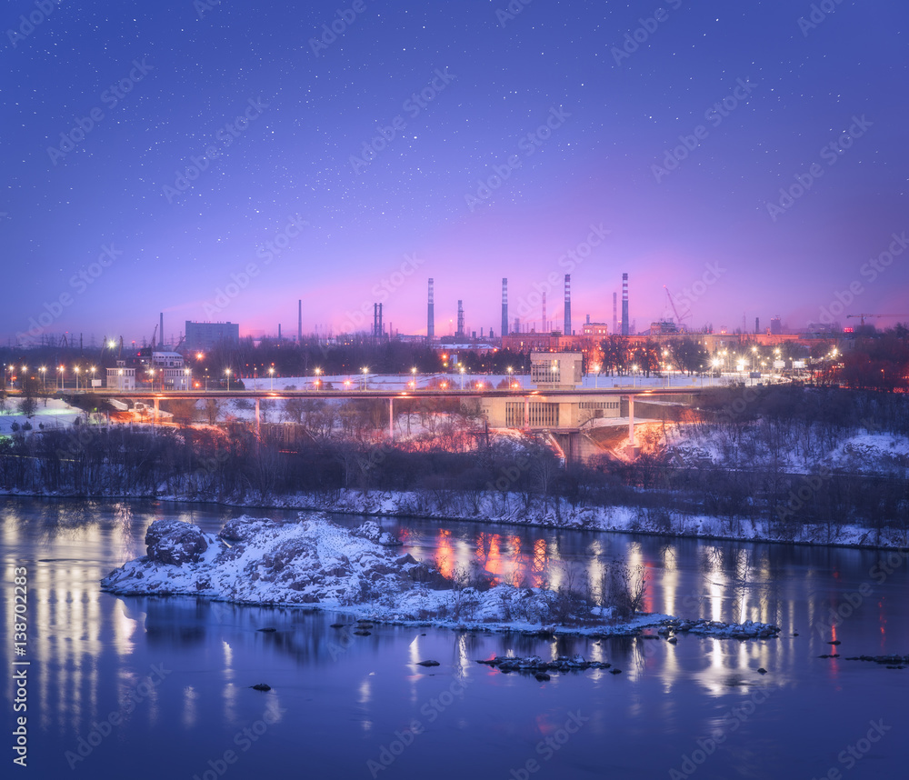 Night cityscape with colorful purple sky with stars, rocks, river, trees, buildings, city illuminati