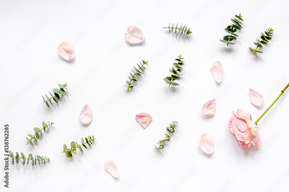 floral pattern with rose petals and eucalyptus on white table top view