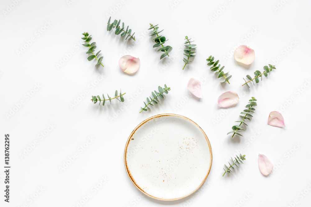 Mock up with rose petals and eucalyptus on white table top view