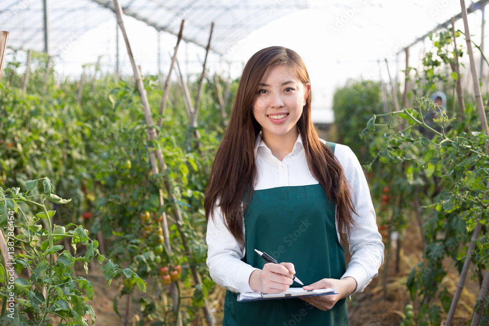 young beautiful asian woman works in green field