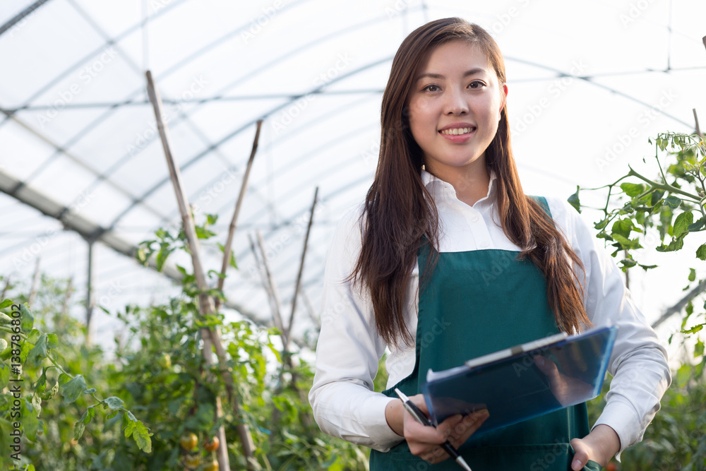 young beautiful asian woman works in green field