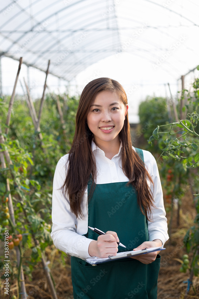 young beautiful asian woman works in green field