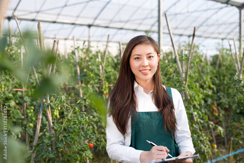 young beautiful asian woman works in green field