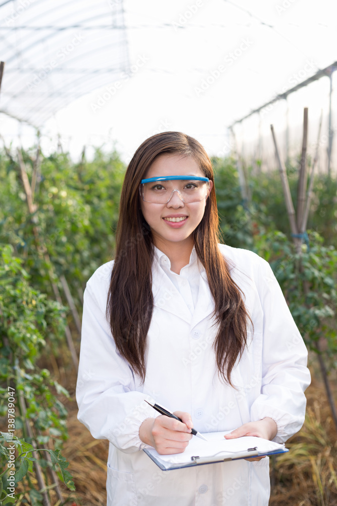 young beautiful asian woman works in green field