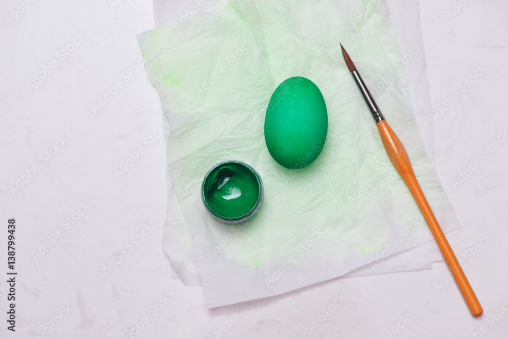 Happy Easter! Painting green easter eggs on table.