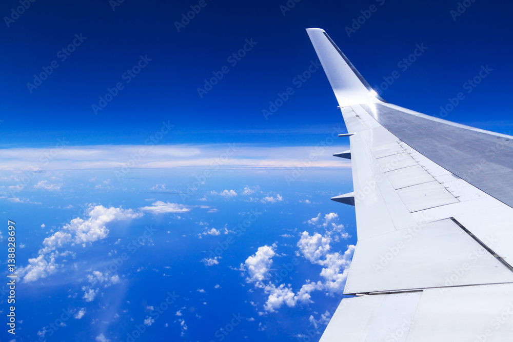 Aerial view of airplane wing over blue sky