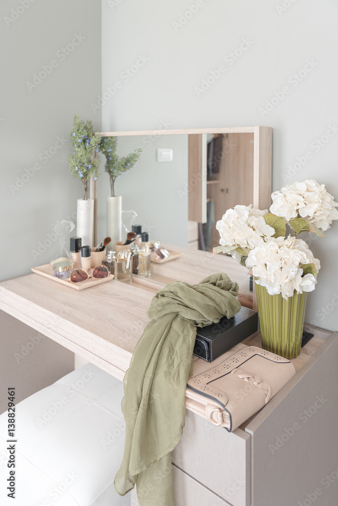 Beauty and make-up concept: table mirror, flowers, perfume, jewelry and makeup brushes on wooden tab