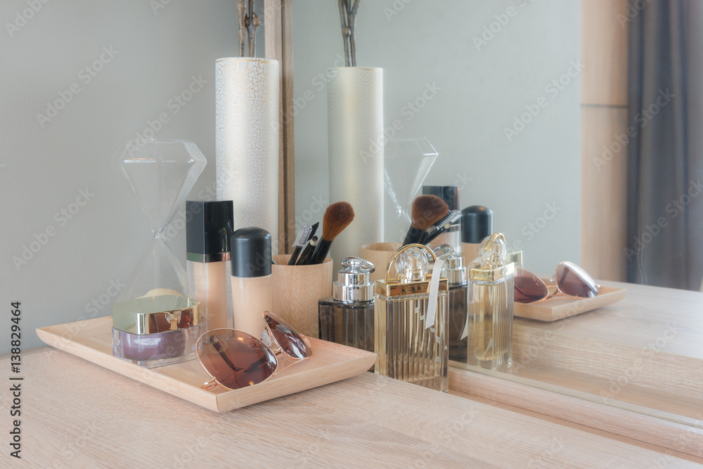 Beauty and make-up concept: table mirror, flowers, perfume, jewelry and makeup brushes on wooden tab