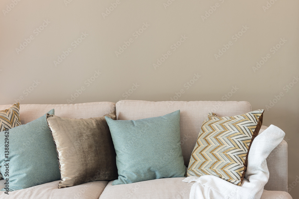 modern living room with green pillows on cozy sofa and wooden lamp