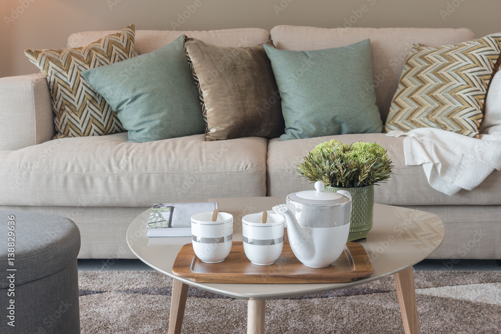 modern living room with green pillows on cozy sofa and wooden lamp