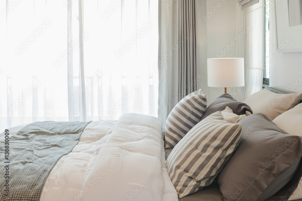 set of pillows and blanket on bed in modern bedroom