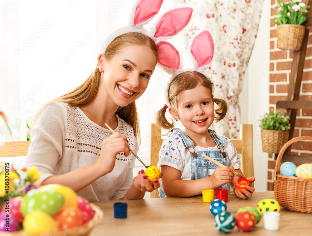 Happy easter! family mother and child daughter paint eggs for holiday Easter