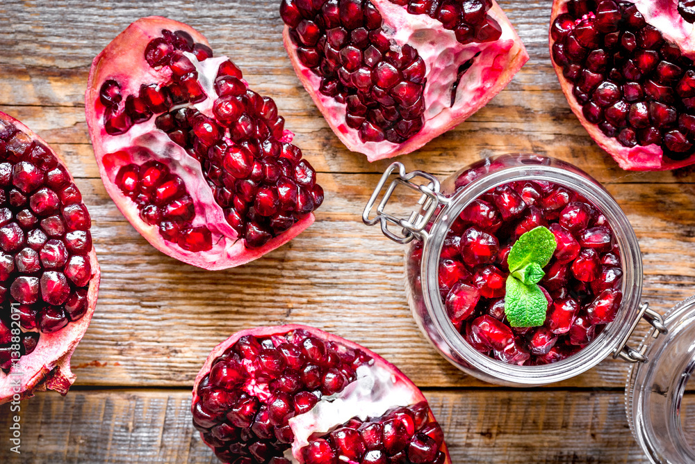 sliced pomegranate on wooden background top view