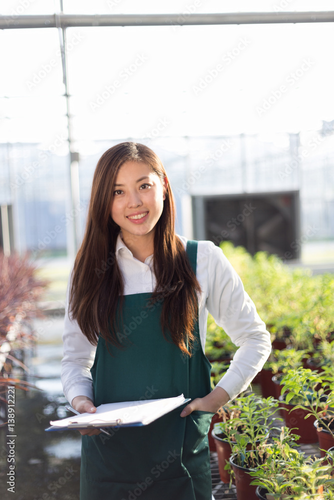 young asian woman works in green house