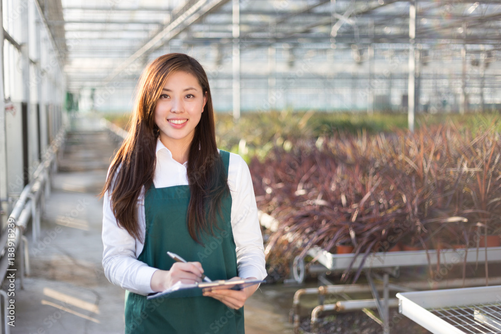 young asian woman works in green house